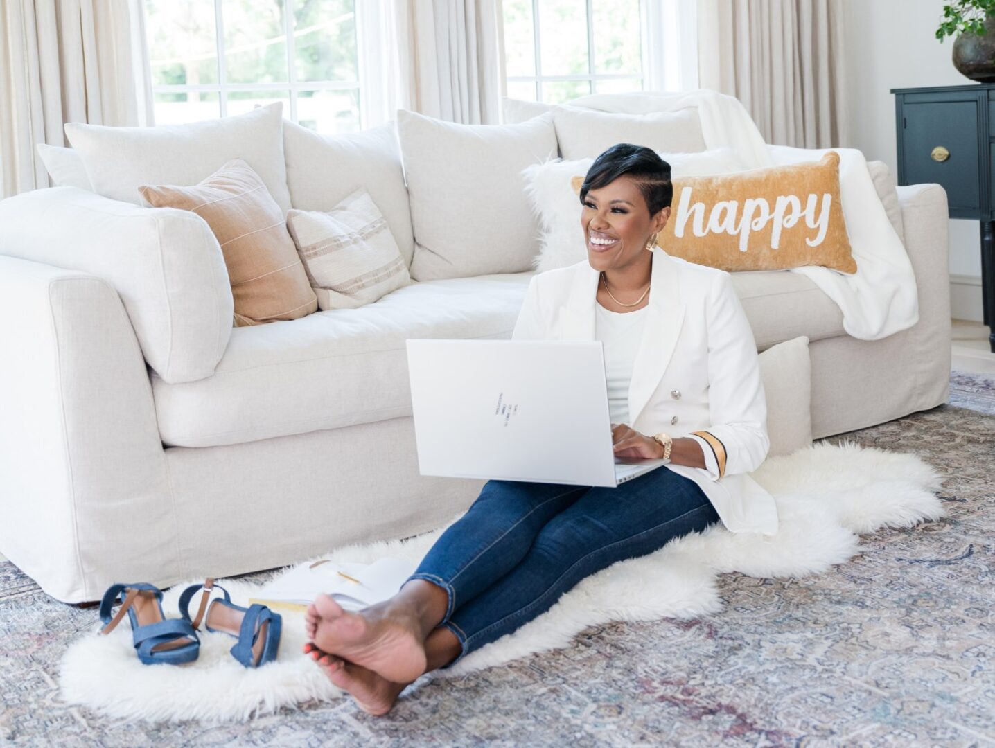 A woman sitting on the floor with her laptop