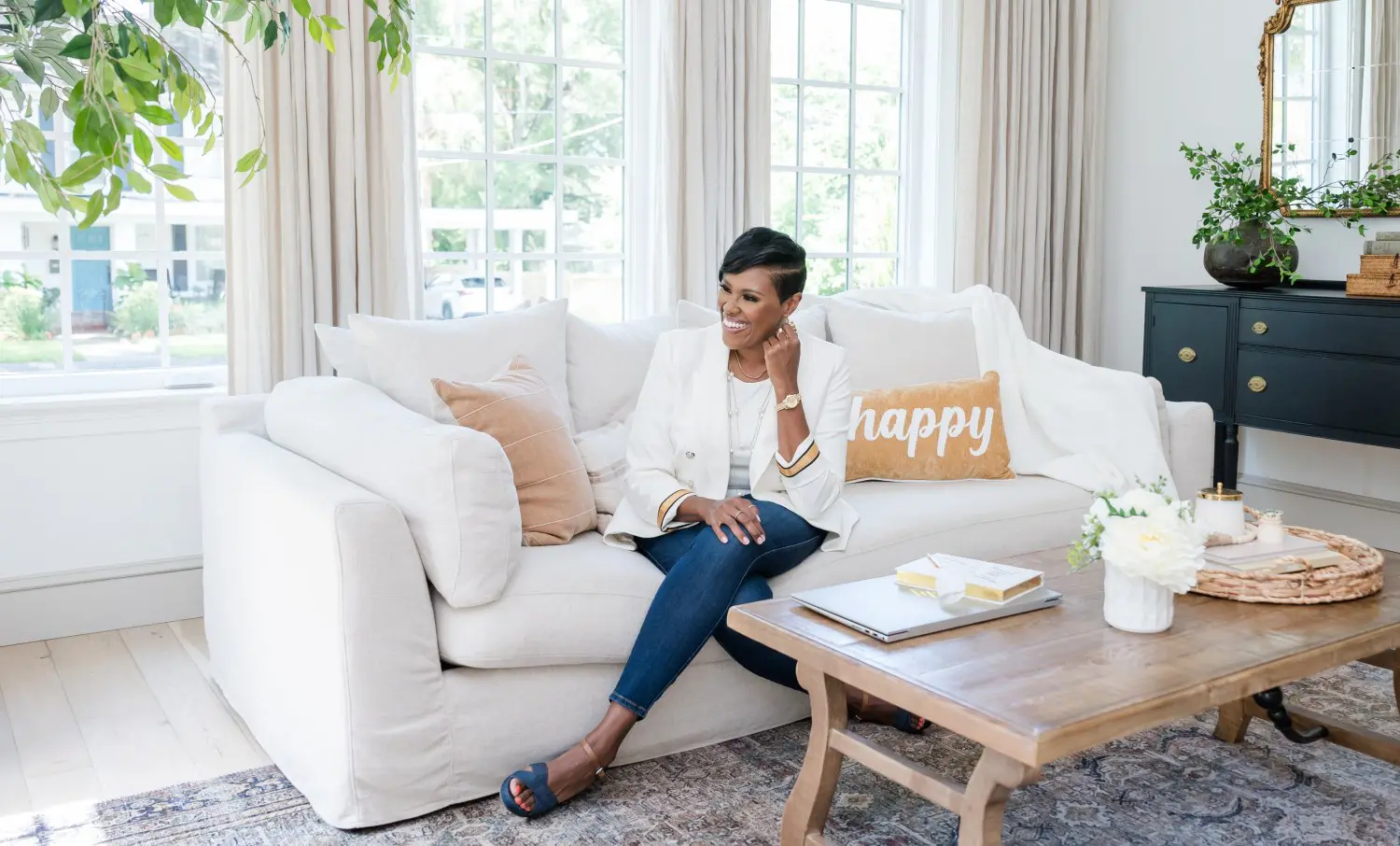 A woman sitting on top of a white couch.