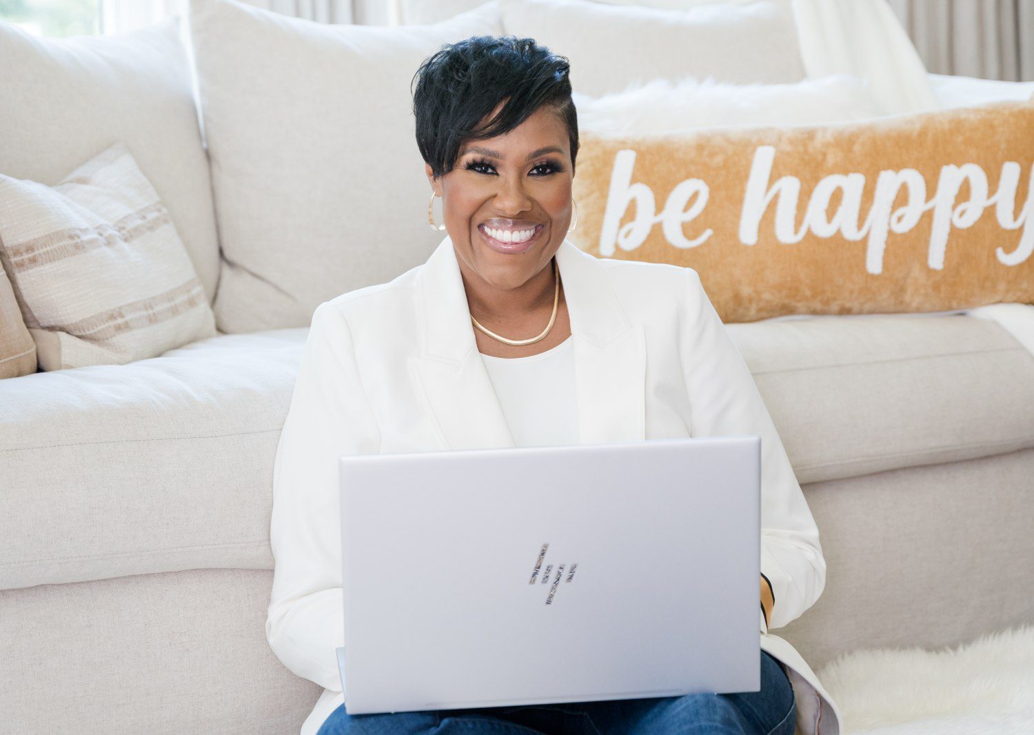 A woman sitting on the couch with her laptop